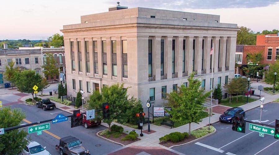 Gallatin, TN Insurance - Gallatin Courthouse at Dusk, a Large Stone Building With Columns, on a Busy Street Corner