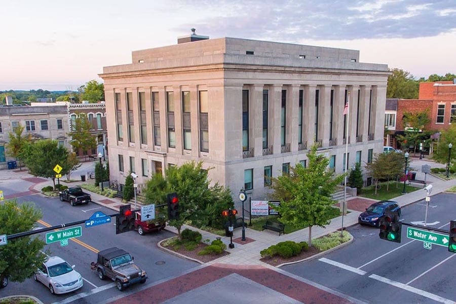 Gallatin, TN Insurance - Gallatin Courthouse at Dusk, a Large Stone Building With Columns, on a Busy Street Corner
